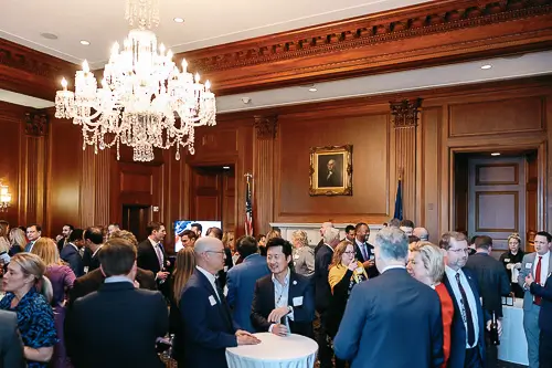 Corporate event photography Washington DC capturing a large gala venue with round tables, chandeliers, and professional event lighting