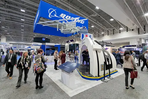 Corporate event photography Washington DC covering a trade show booth with branded displays and attendee interaction