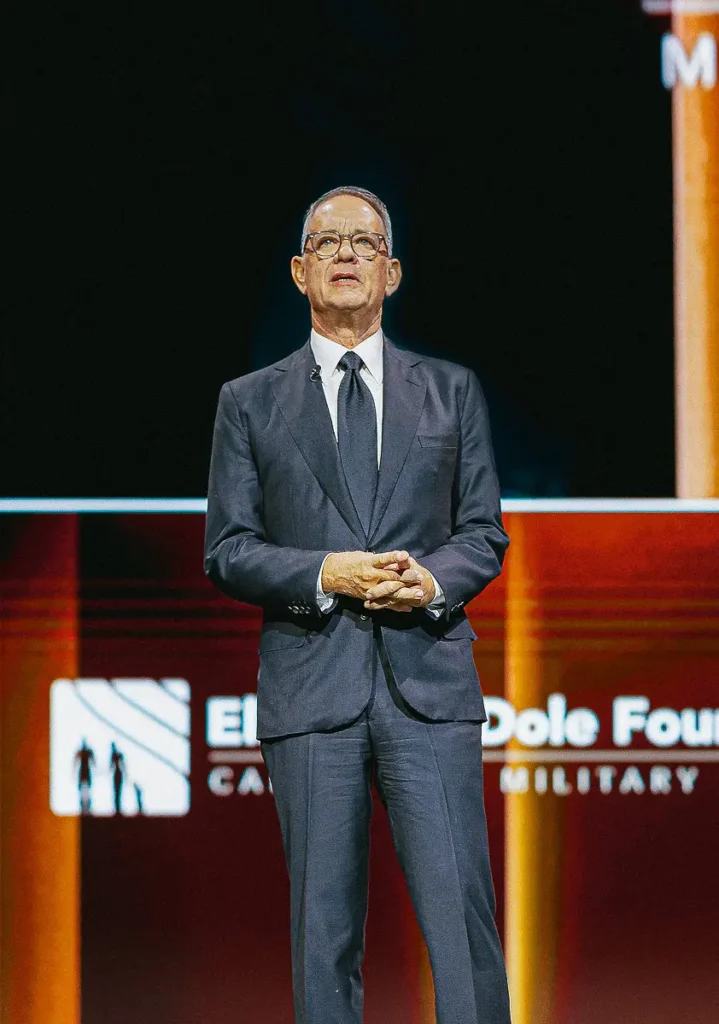 Keynote speaker presenting on stage at a high-profile Washington DC fundraising event with dramatic lighting