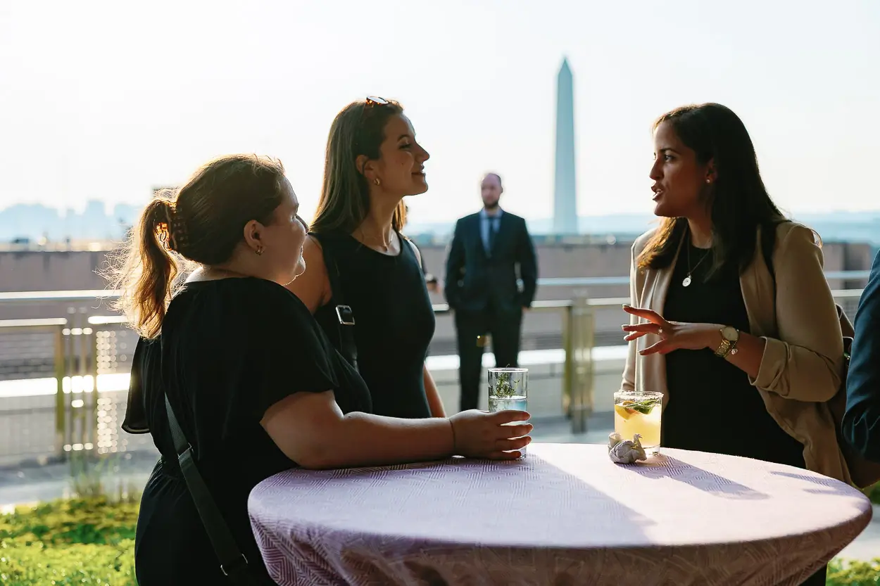 Executives networking at a Washington DC event with a monument view in the background