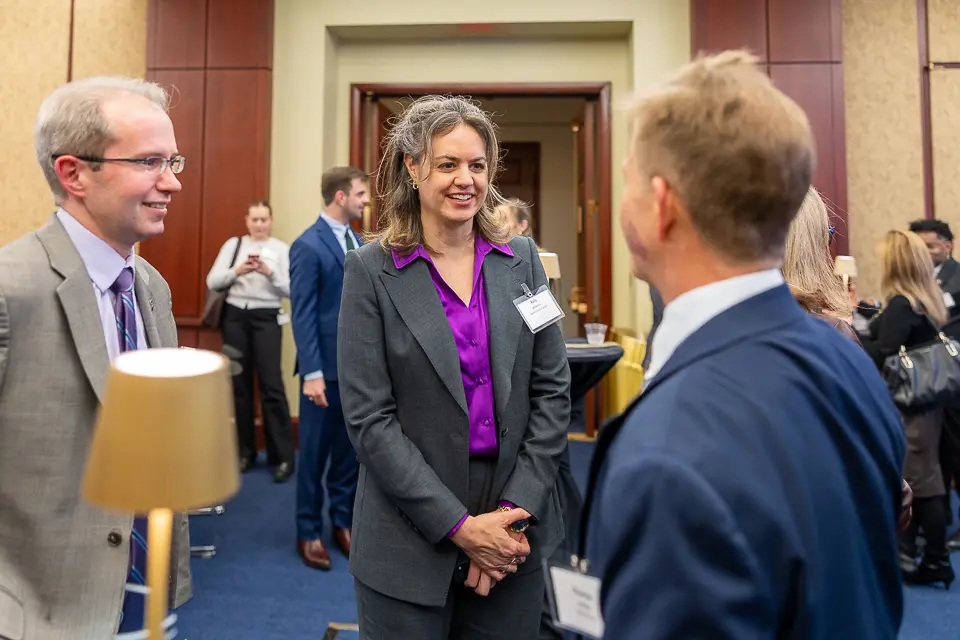 Corporate event guests having a natural networking conversation during a Washington DC reception