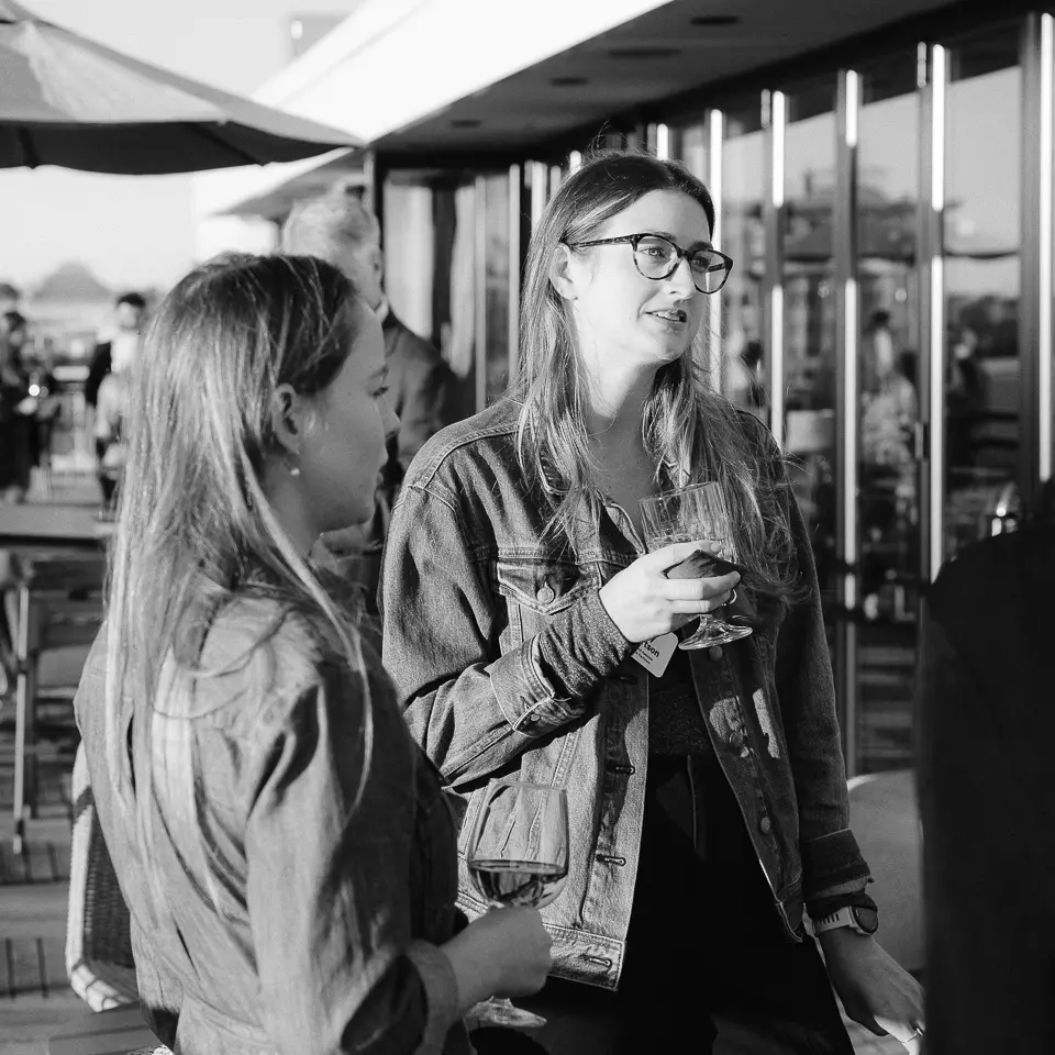 Black and white candid portrait of guests talking during a rooftop networking reception in Washington DC