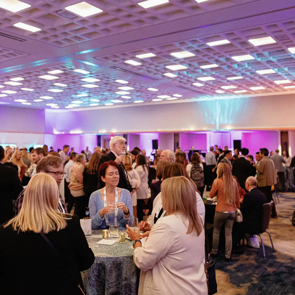 Reception crowd under purple lighting during the FDA-PDA Annual Conference