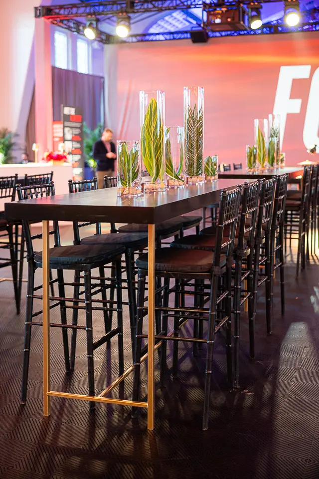 High-top cocktail tables and chairs arranged in front of the University of Maryland Forward stage setup