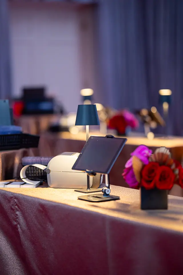 Registration table with lamp, tablets, red flowers, and campaign materials at the University of Maryland Forward event