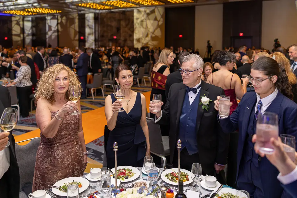 Guests raising glasses and applauding at a dinner table during the Herb Wegner Awards 2026 celebration.