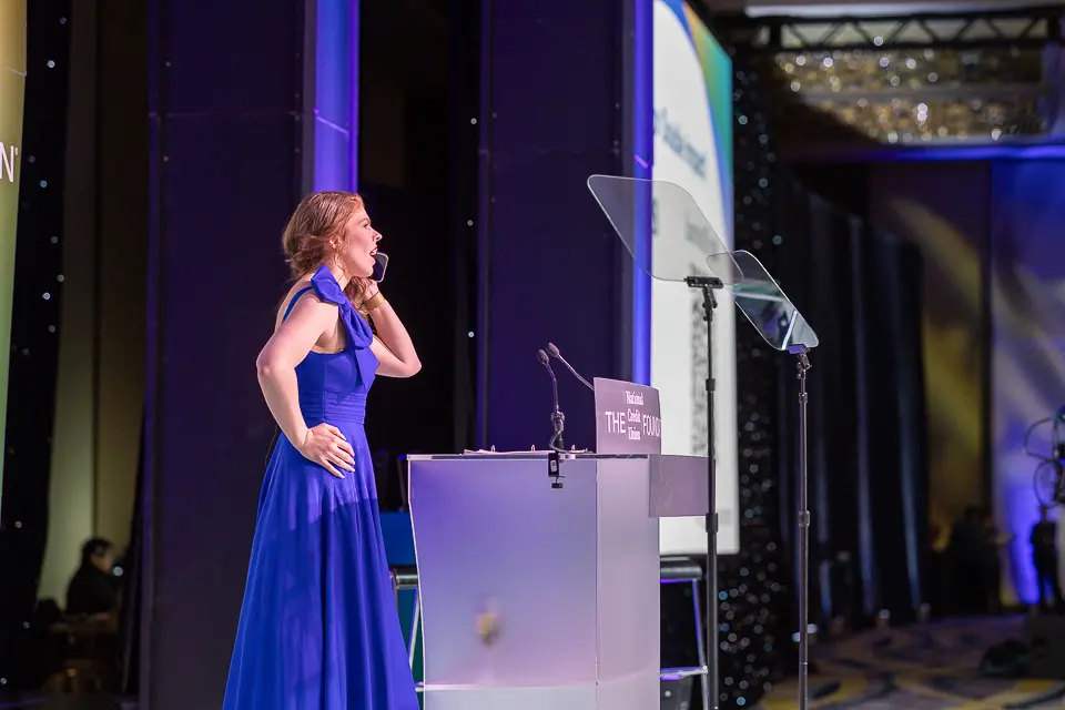 Woman speaker addressing the Herb Wegner Awards 2026 audience from the stage podium.