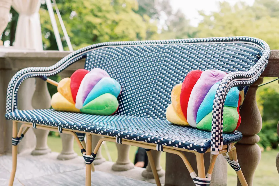 Striped lounge seating with colorful pillows on a garden terrace