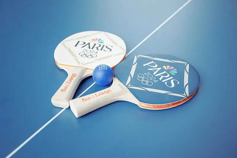 Paris-themed paddle game equipment on a blue activity court