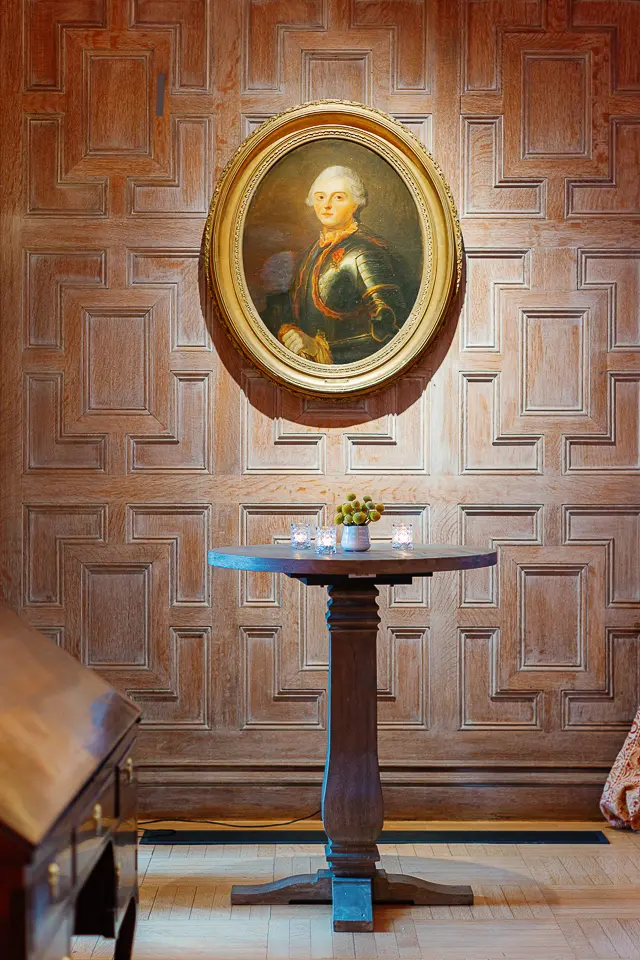 Table set for a Paris-themed event in an orange room with framed artwork in the background