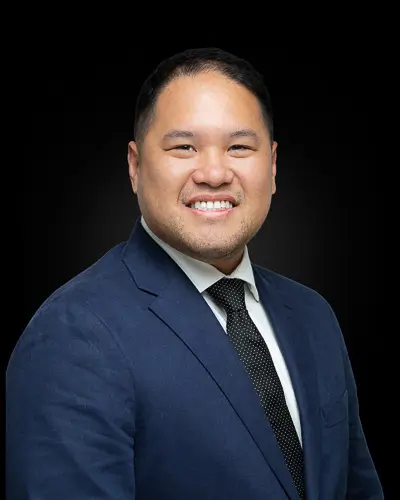 Professional corporate headshot of an Asian male professional photographed against a black background in Washington DC by District Pixel